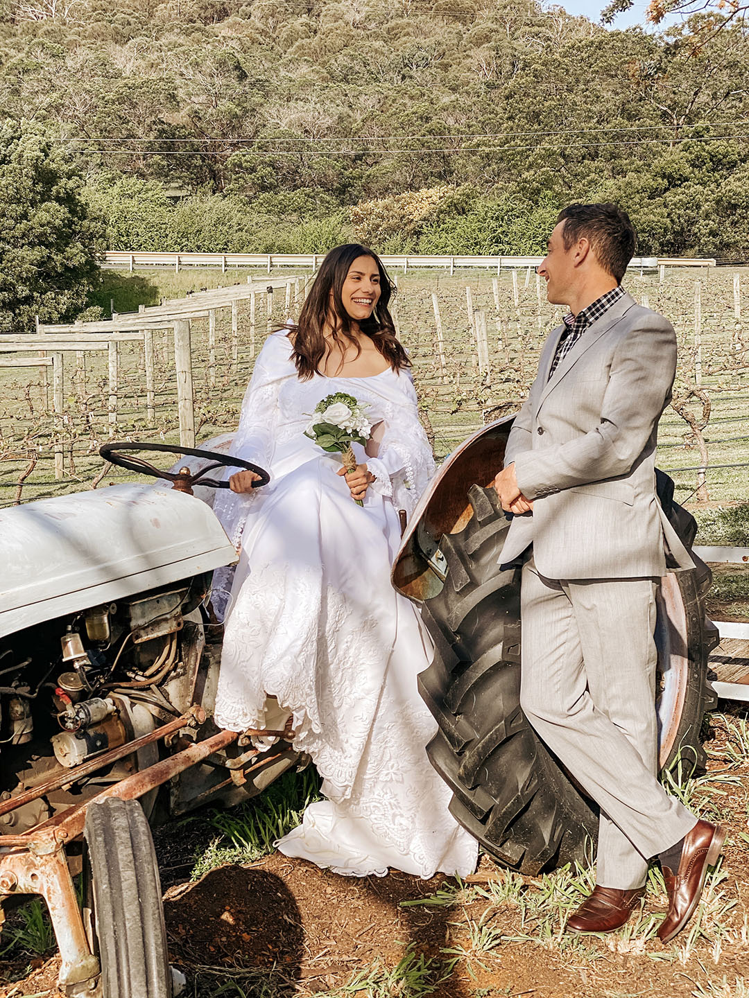 Happy couple on their wedding day in the vineyard with tractor